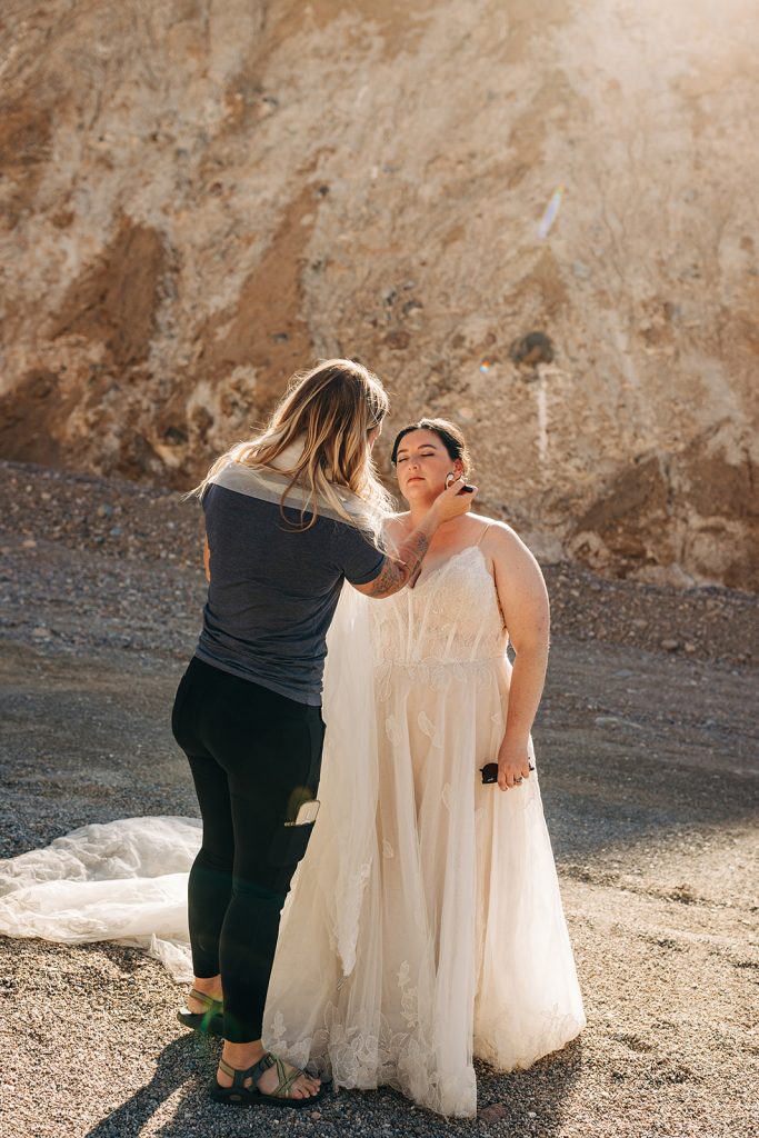 A hair and make up artist does make up for the bride on location.